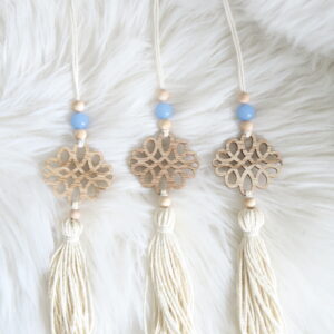 Chalcedoon hanger met houten ornament, blauwe kraal en kwast op zachte witte achtergrond