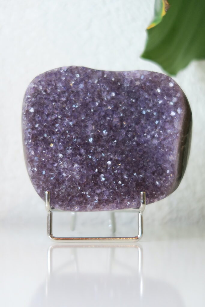 Regenboog Amethist cluster op standaard – kleurrijk amethistkristal met natuurlijke regenbooginsluitsels door onderliggende mineralen.