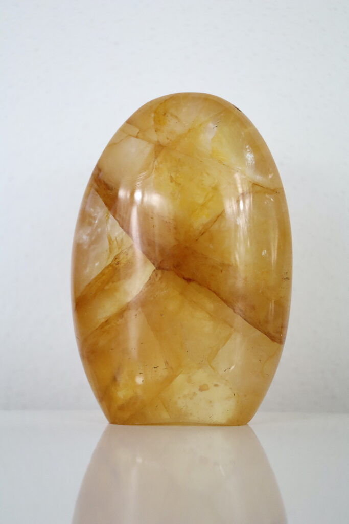 Golden Healer sculptuur uit Madagaskar – glanzend gepolijste limoniet in kwarts met gouden gloed.
