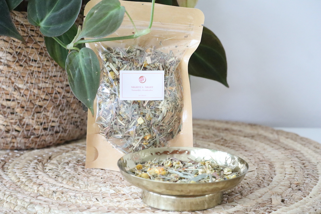 Nightea Night natuurlijke kruidenthee in kraft stazak met venster, gevuld met citroengras, kamille en lavendel, gefotografeerd in een rustige natuurlijke setting.