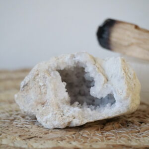 Marokkaanse kwarts geode van 165 gram met kristalrijke binnenzijde op een natuurlijke ondergrond.