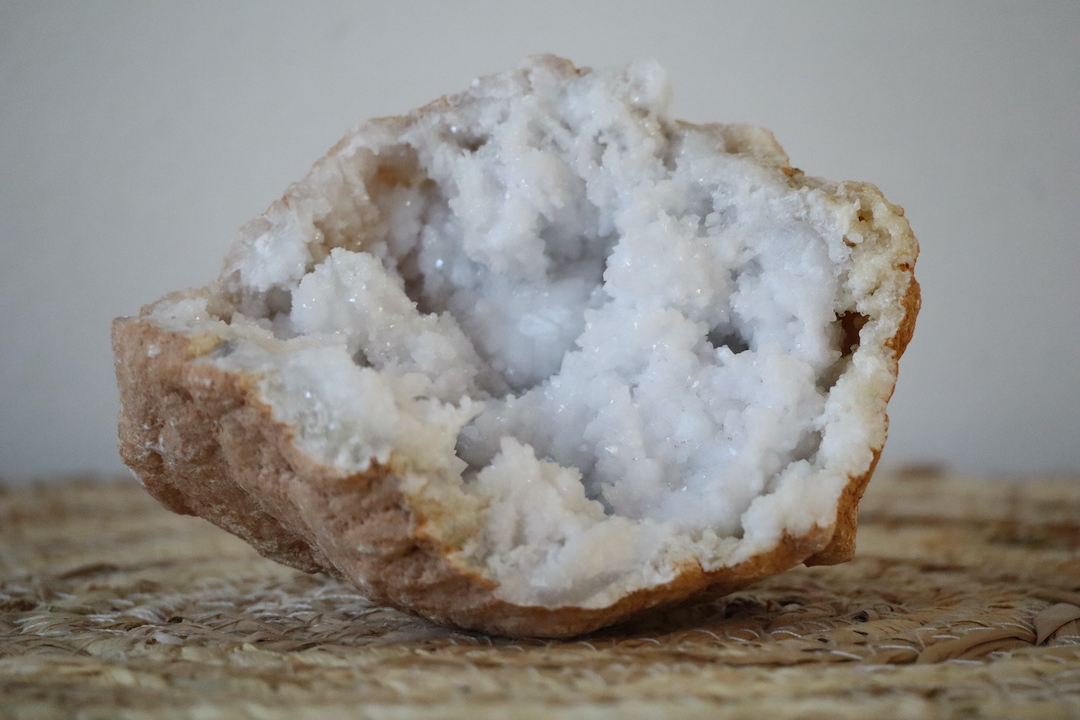 Close-up van de kristalrijke binnenkant van een Marokkaanse kwarts geode met glinsterende rozetstructuren.