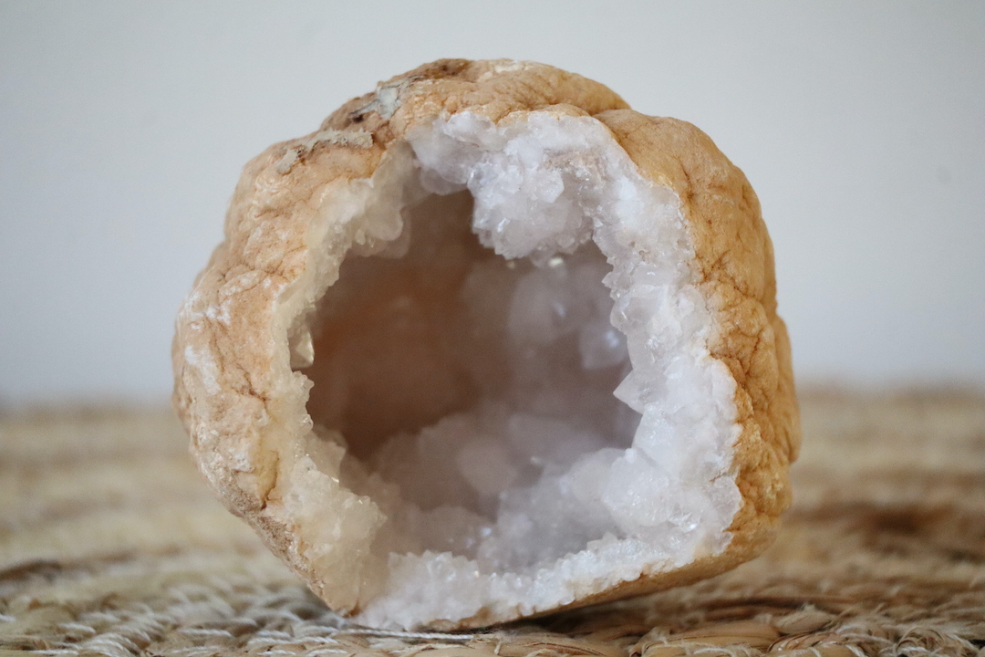 Marokkaanse Bergkristal geode met grotere kristalpunten, open grot en warme beige buitenkant.