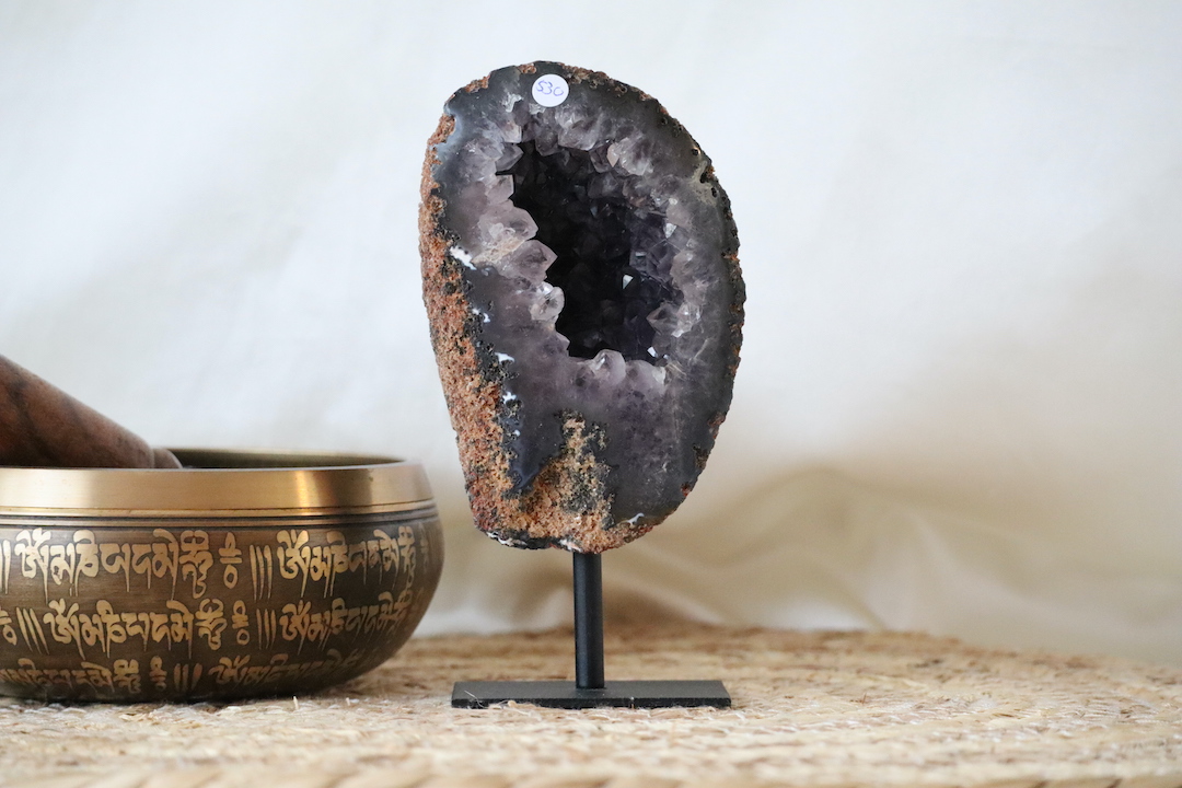 Amethist geode op standaard met open kristalhart en ruwe buitenzijde, natuurlijk kristalobject van 435 gram.