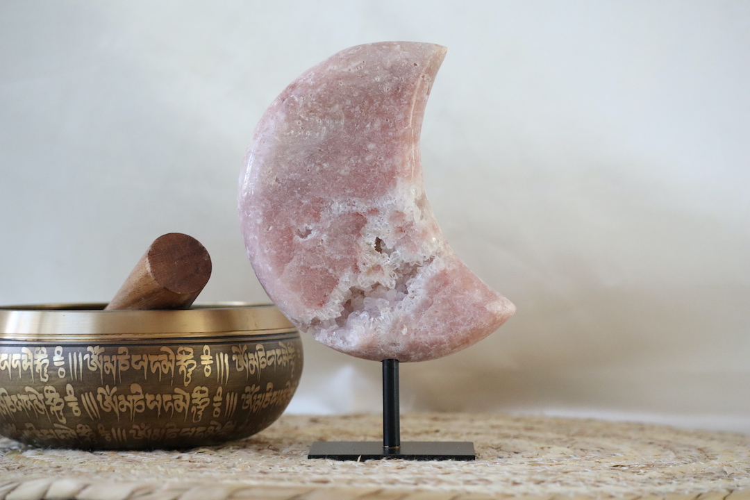 Druzy roze chalcedoon met kwarts maan op zwarte metalen standaard, gepolijste maanvorm met centrale kwarts rozet, gefotografeerd in natuurlijk daglicht.