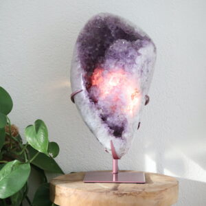 Grote Amethist op standaard met verlichting en gepolijste buitenzijde, natuurlijk kristalobject van 11 kg met warm verlicht kristalinterieur.