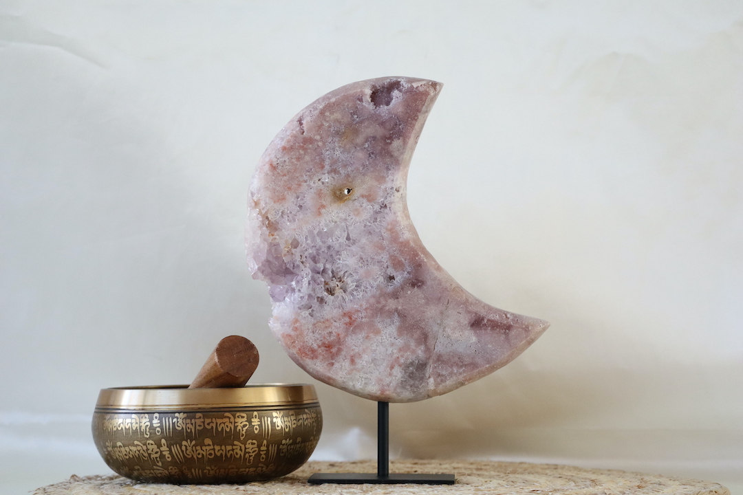 Amethist met roze chalcedoon maan op zwarte metalen standaard, groot natuurstuk met zachte roze en paarse tinten en subtiel hersteld detail, gefotografeerd in natuurlijk daglicht.