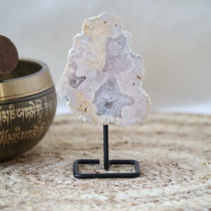 Kleine roze amethist met kwarts op standaard, lichtroze natuursteen met open kristalstructuur.