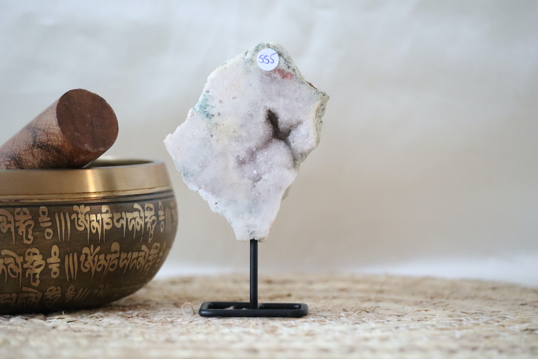 Kleine druzy roze chalcedoon op standaard, lichtroze natuursteen met fijne kristalstructuur.