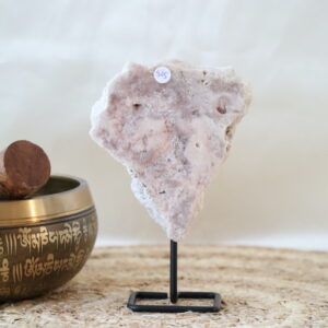 Roze chalcedoon met kwarts op zwarte metalen standaard, zachte poederroze tinten met kleine kristallijne openingen, gefotografeerd in natuurlijk daglicht tegen een rustige interieurachtergrond.