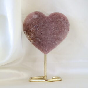 Roze chalcedoon hart op standaard met zichtbaar kwartsstuk aan de zijkant