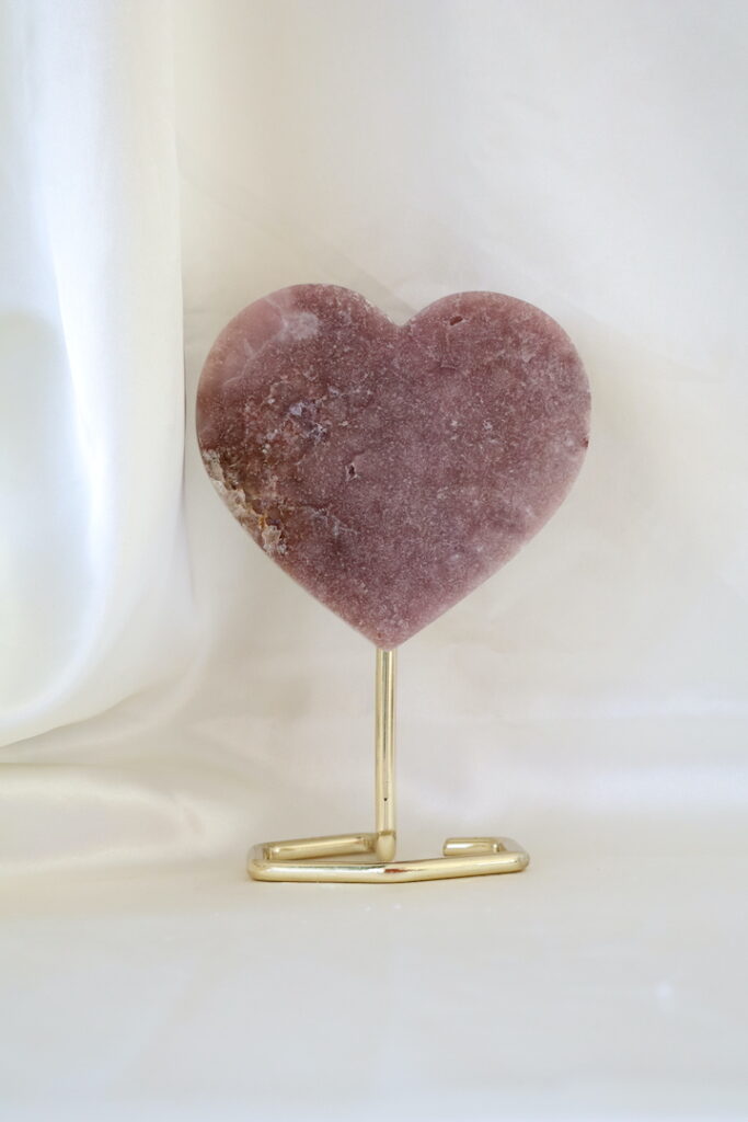 Roze chalcedoon hart op standaard met zichtbaar kwartsstuk aan de zijkant