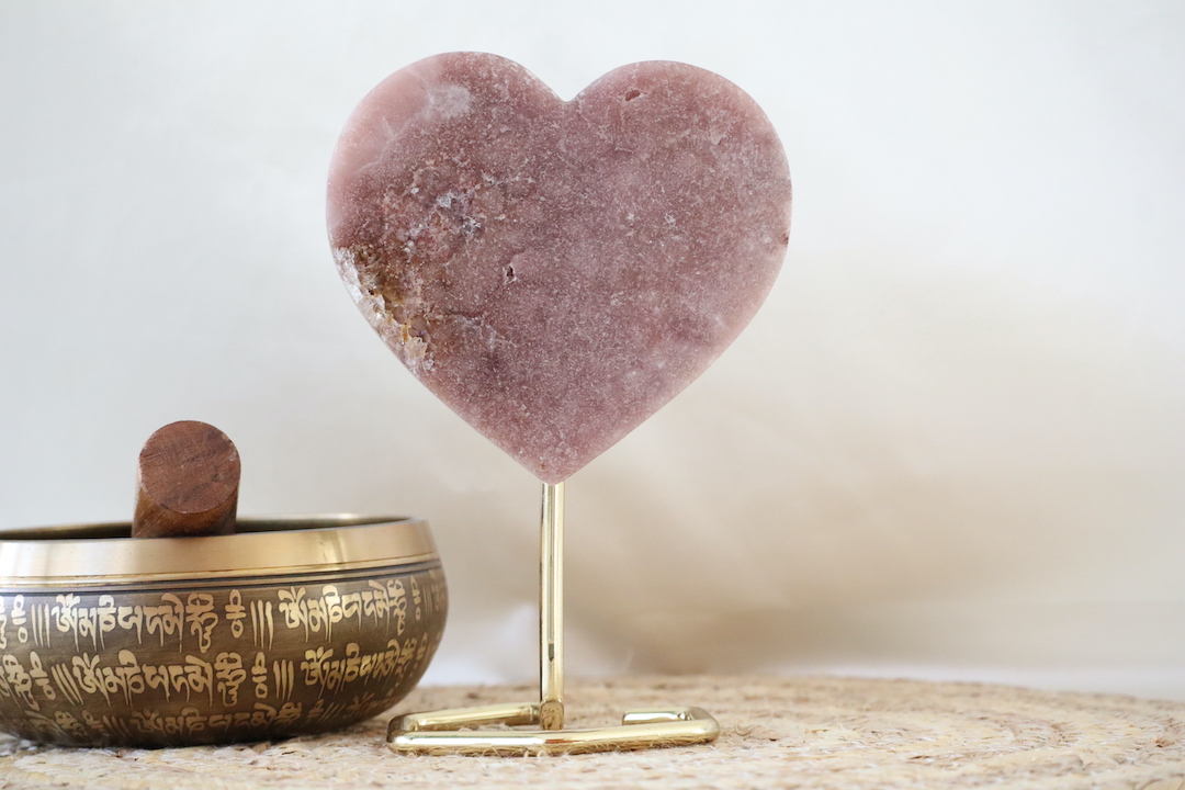 Roze chalcedoon hart op standaard met zichtbaar kwartsstuk aan de zijkant