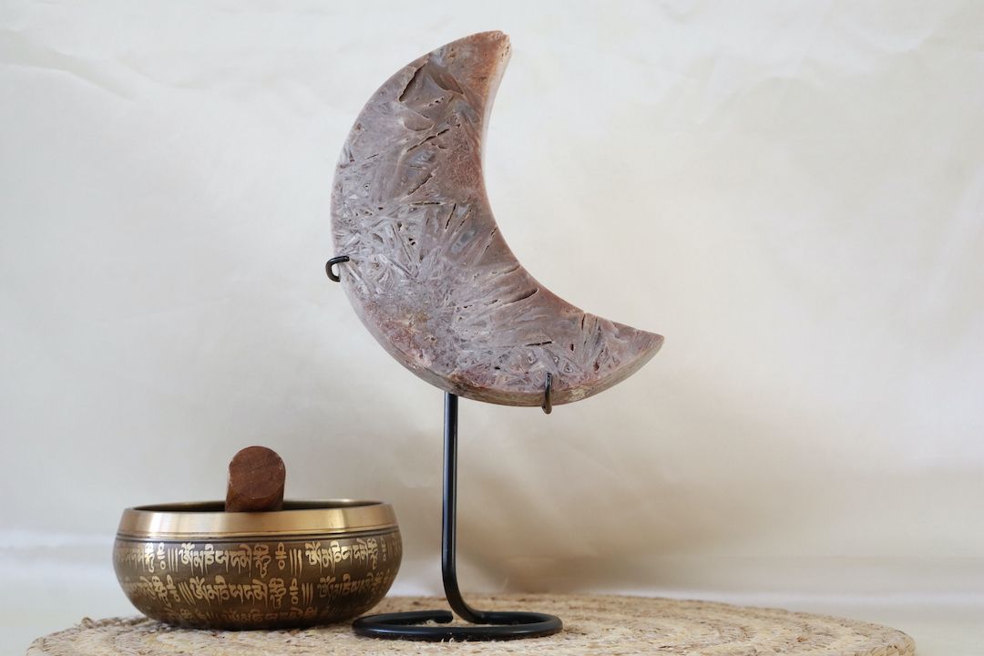 Roze chalcedoon met rutiel maan op zwarte metalen standaard