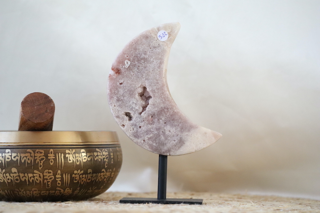 Roze Chalcedoon met druzy in maanvorm op zwarte metalen standaard