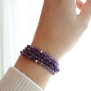 Chevron Amethist armband 4 mm gedragen om de pols met subtiele paarse tint.
