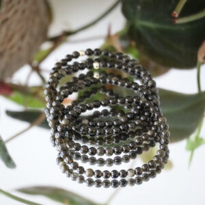 Close-up van goud obsidiaan armband 4 mm met natuurlijke gouden glans.