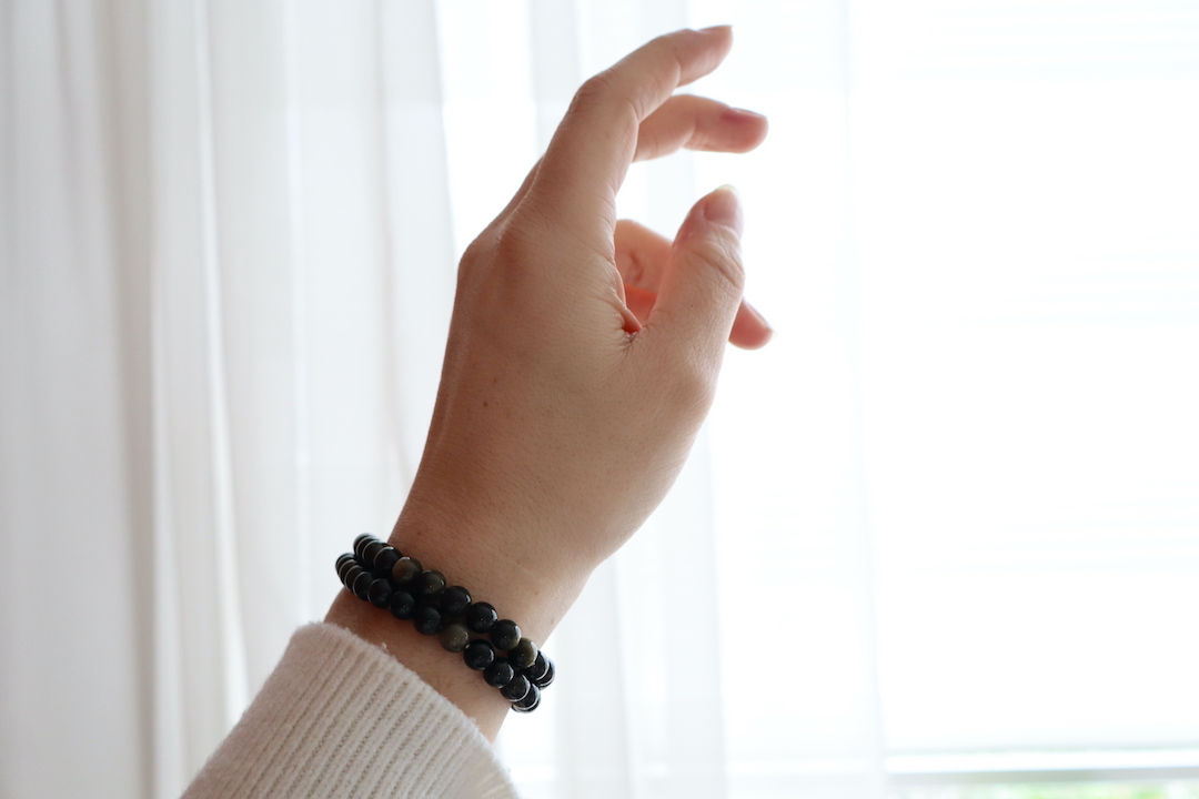 Goud obsidiaan armband 6 mm kralen met subtiele gouden glans gedragen om de pols.