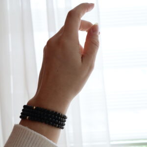 Goud obsidiaan armband 4 mm gedragen om de pols met subtiele gouden reflectie.