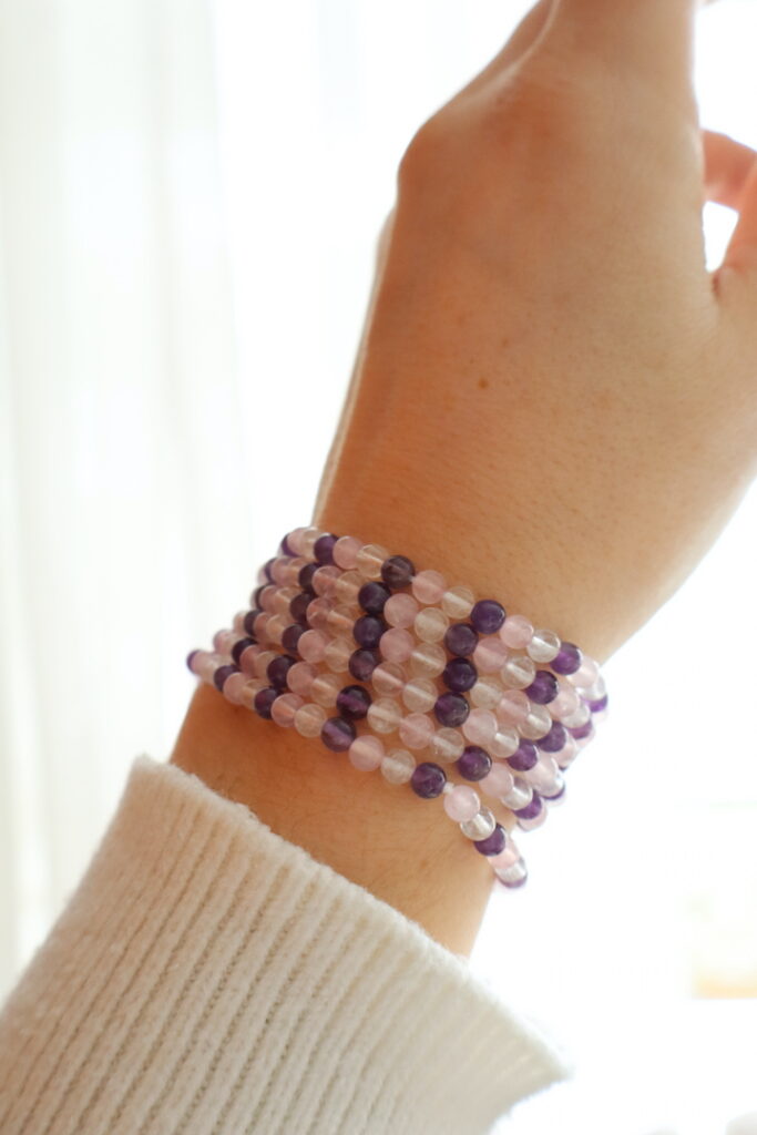Gouden Driehoek armband 4 mm gedragen om de pols in zachte paarse en roze tinten.