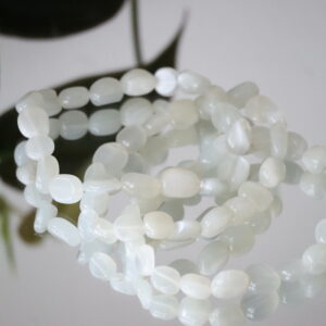 Close-up van Groene Maansteen trommelsteen armband 6-8mm met melkachtig groene glans.