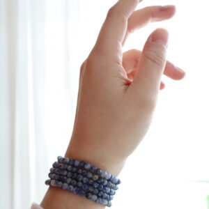 Sodaliet armband 4 mm gedragen om de pols met subtiele blauwe tint.