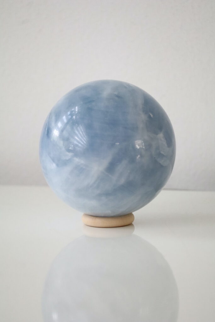 Achterzijde van Blauwe Calciet bol met natuurlijke kristalstructuren