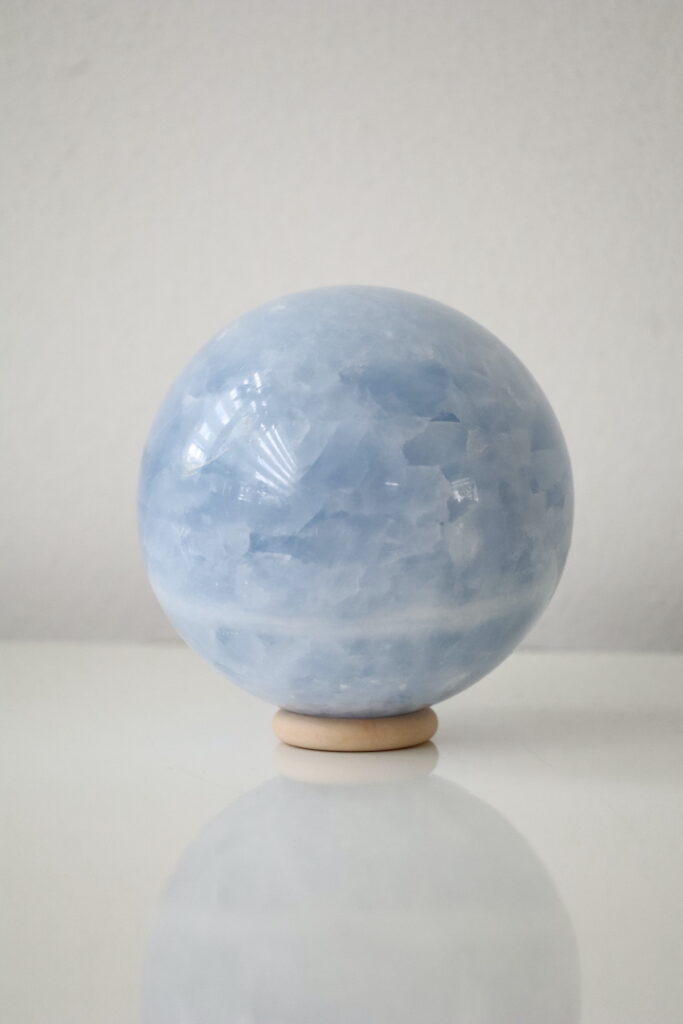 Achterzijde van Blauwe Calciet bol met natuurlijke kristalstructuren