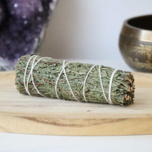 Organische Ceder Smudge Stick van 10 cm op een houten schaal.