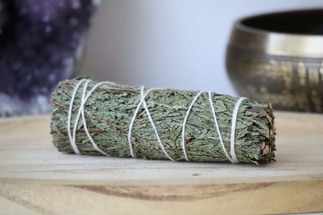 Ceder Smudge Stick van dichtbij op een houten ondergrond.