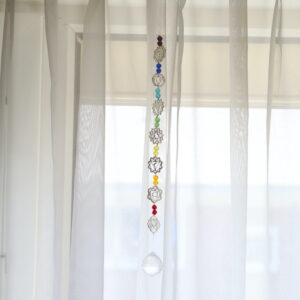 Chakra zonnevanger van 46 cm hangend voor een raam met zeven chakrasymbolen en kristalhanger.