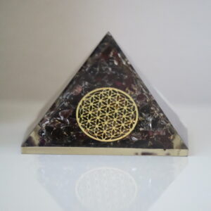 Granaat Orgoniet Piramide met Flower of Life op een witte achtergrond.