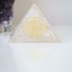 Seleniet Orgoniet Piramide met Sri Yantra van 40-45 mm op een witte ondergrond.