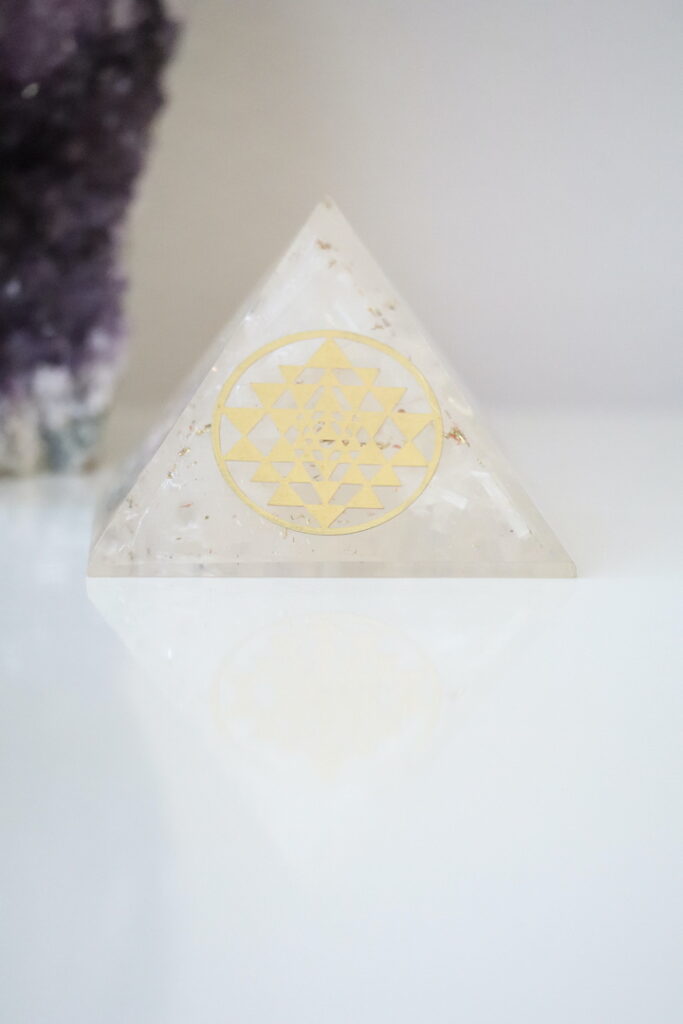 Seleniet Orgoniet Piramide met Sri Yantra van 40-45 mm op een witte ondergrond.