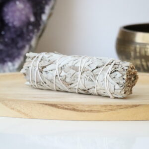 Witte Salie Smudge Stick van organische witte salie op een houten schaal.