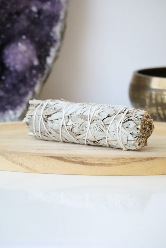 Witte Salie Smudge Stick van organische witte salie op een houten schaal.