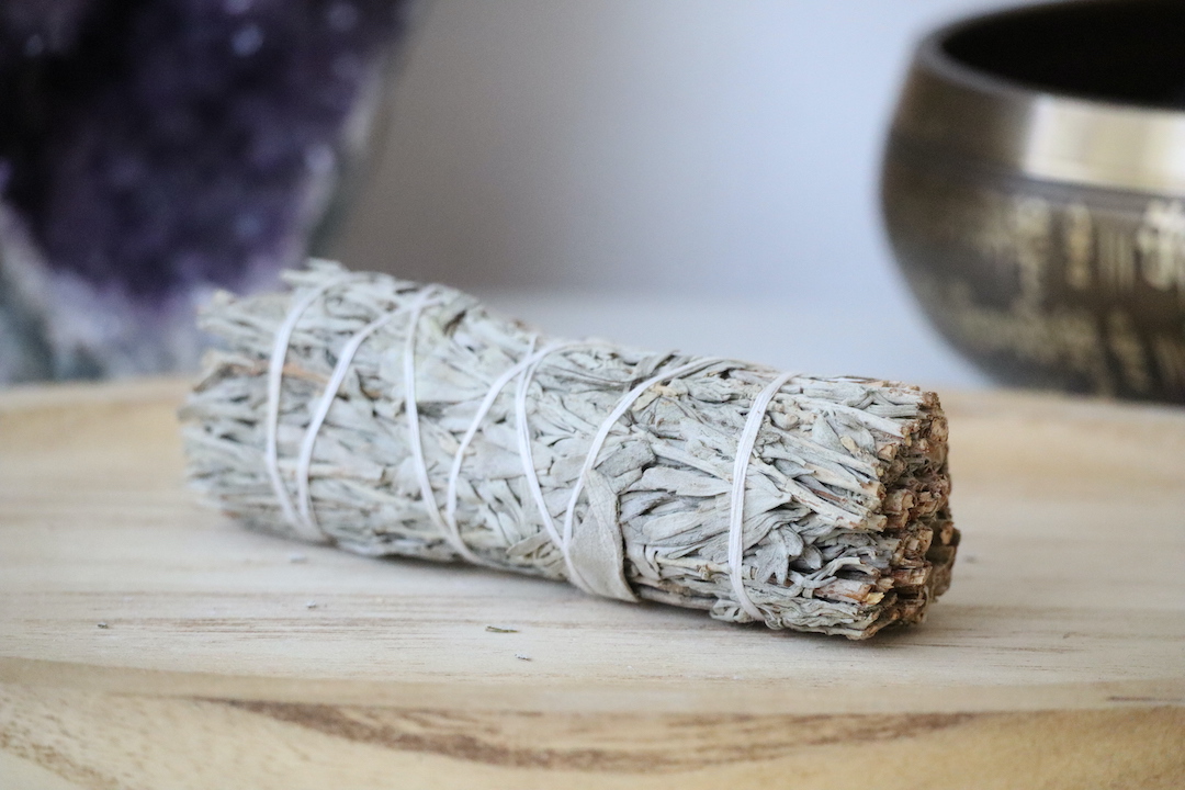 Organische Witte & Blauwe Salie Smudge Stick op een houten ondergrond.