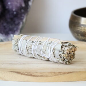 Organische Witte Salie & Citroengras Smudge Stick op een houten schaal.