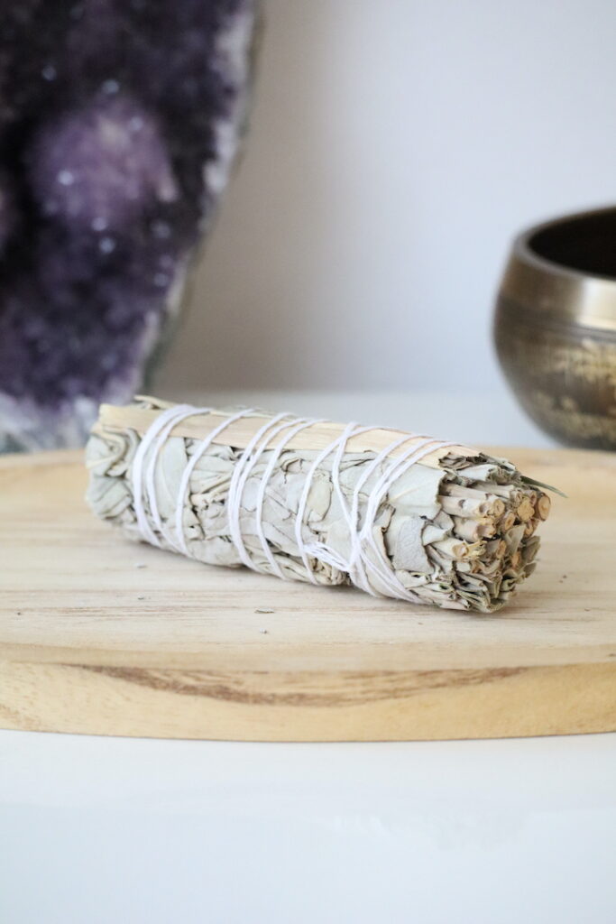 Organische Witte Salie & Citroengras Smudge Stick op een houten schaal.