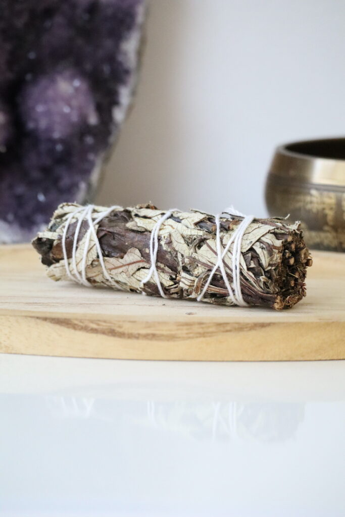 Organische Yerba Santa Smudge Stick van 10 cm op een houten schaal.