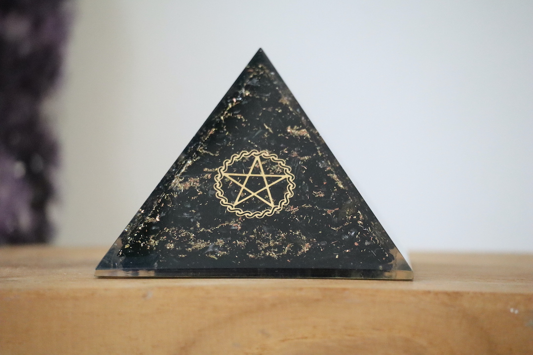 Zwarte Toermalijn Orgoniet Piramide van 75 mm op houten ondergrond.