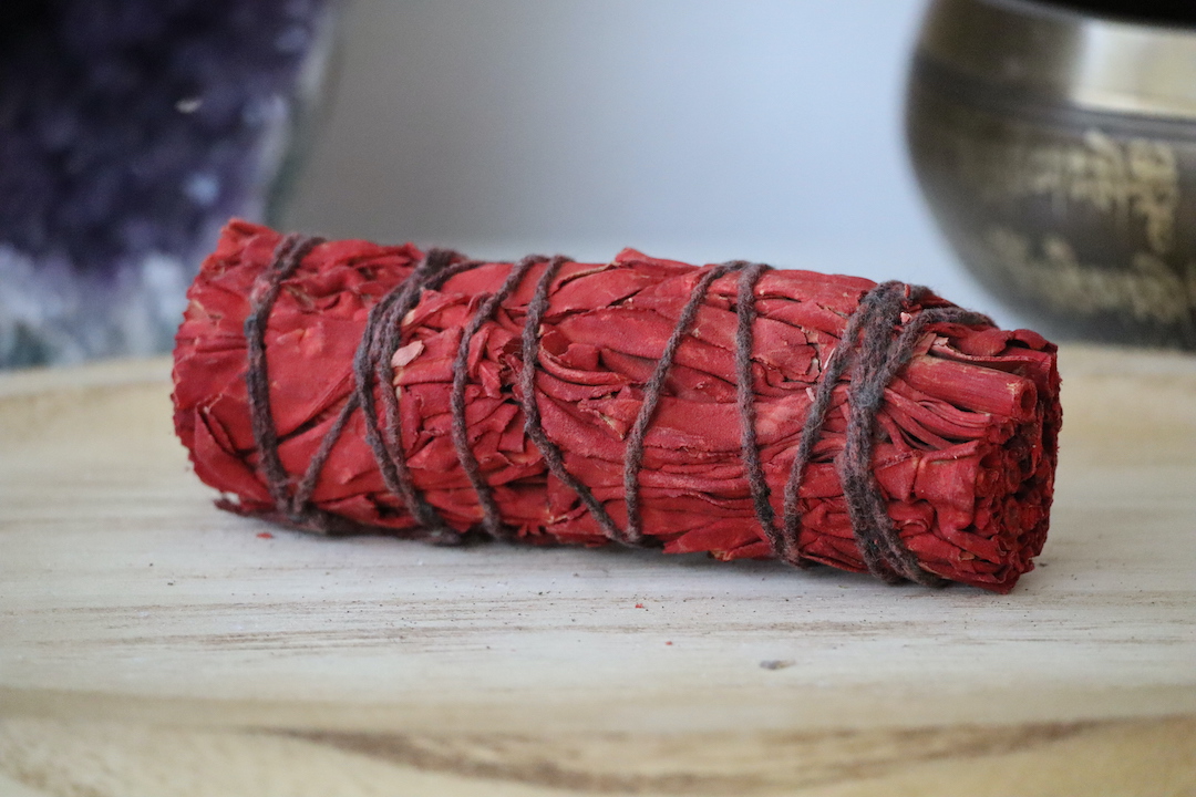 Dragon's Blood Smudge Stick van dichtbij op een houten ondergrond.