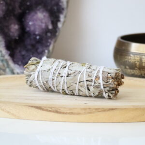 Witte Salie & Jeneverbes Smudge Stick van 10 cm op een houten schaal.