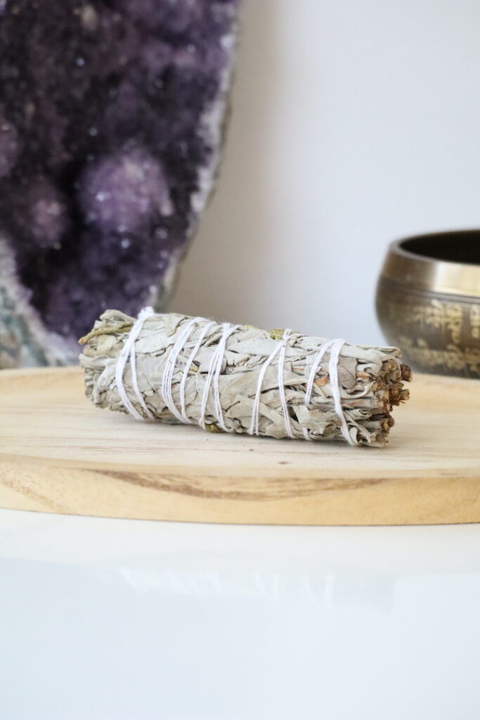 Witte Salie & Jeneverbes Smudge Stick van 10 cm op een houten schaal.