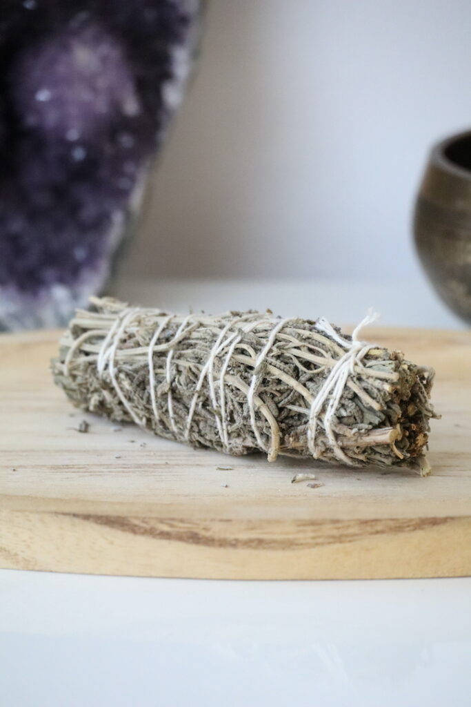 Witte Salie & Lavendel Smudge Stick van 10 cm op een houten schaal.