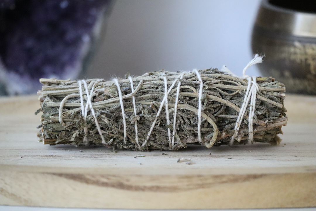 Witte Salie & Lavendel Smudge Stick van dichtbij op een houten ondergrond.