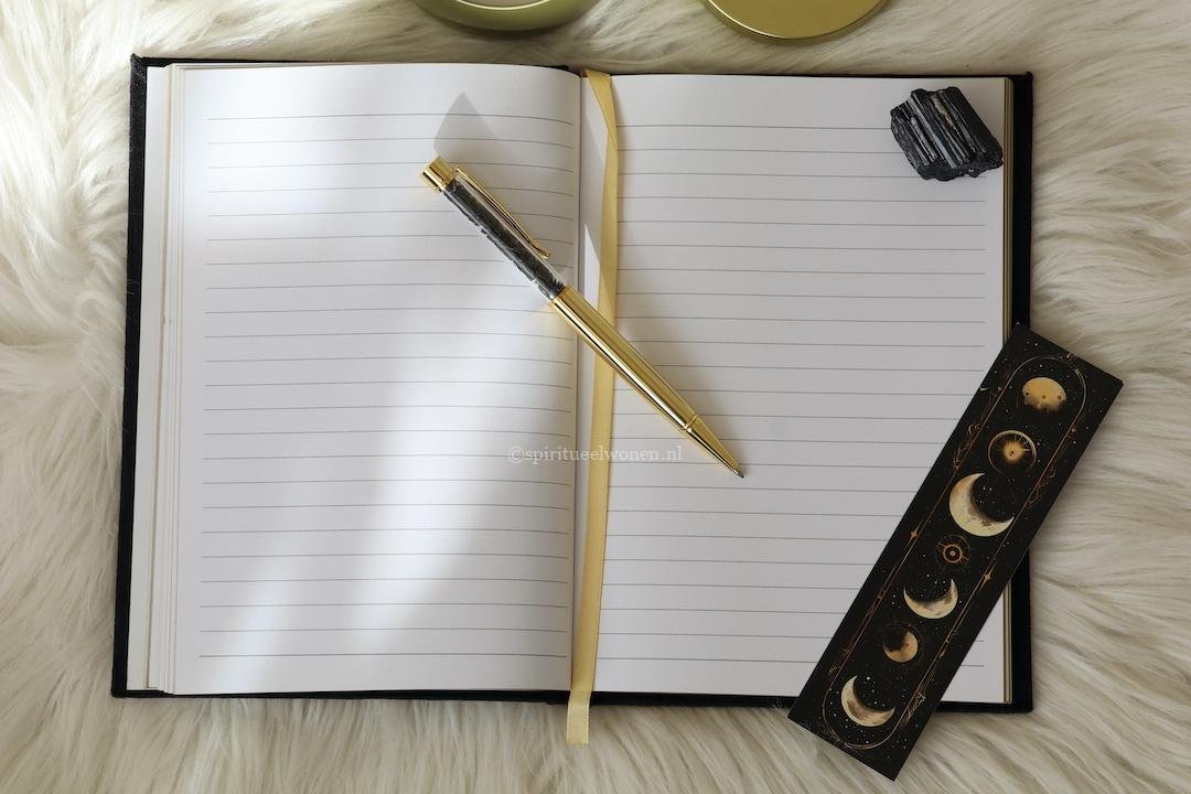 Binnenzijde van het sterrenbeeld notitieboekje met 200 gelinieerde pagina's, gouden leeslint en obsidiaan pen.