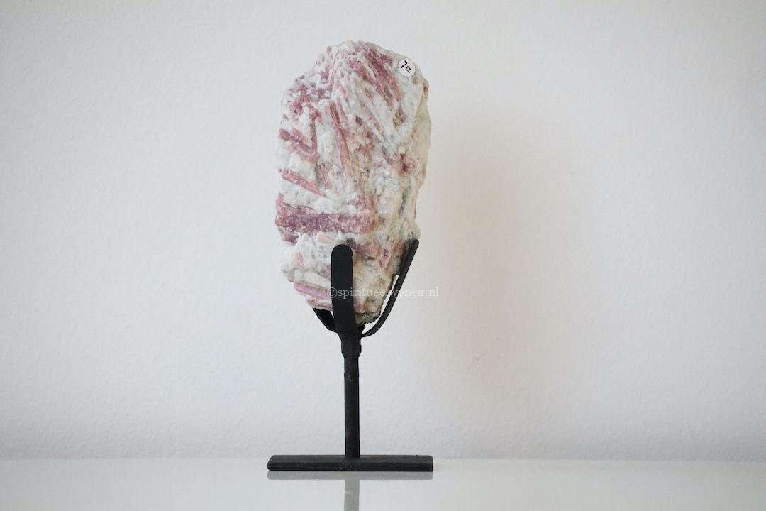 Hoge slanke roze toermalijn in kwarts op zwarte standaard als natuurlijke woondecoratie.