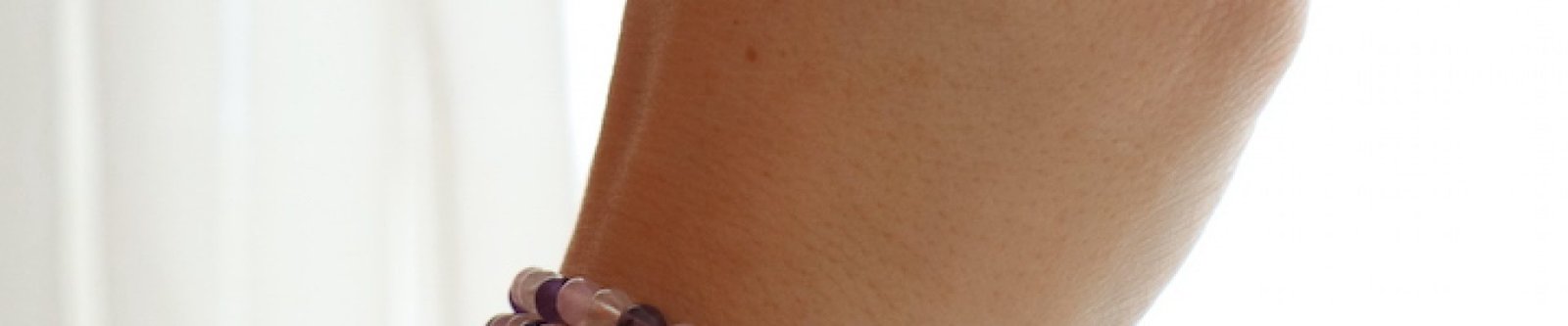 Gouden Driehoek armband 4 mm gedragen om de pols in zachte paarse en roze tinten.