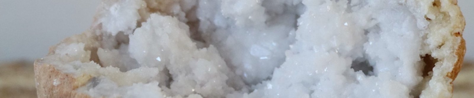 Marokkaanse kwarts geode van 405 gram met rozet-kwartsformaties, staand op een natuurlijke ondergrond.